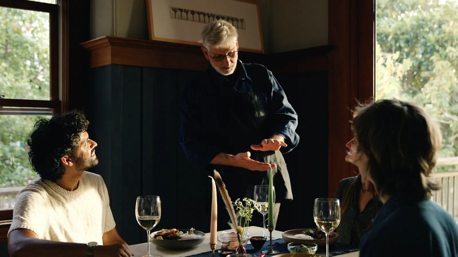 Friends at a candlelit dinner table after cooking together